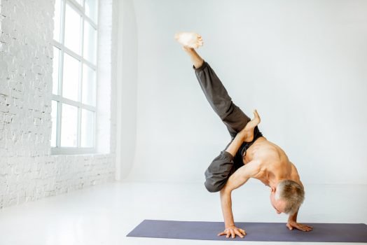 Senior man practising yoga indoors