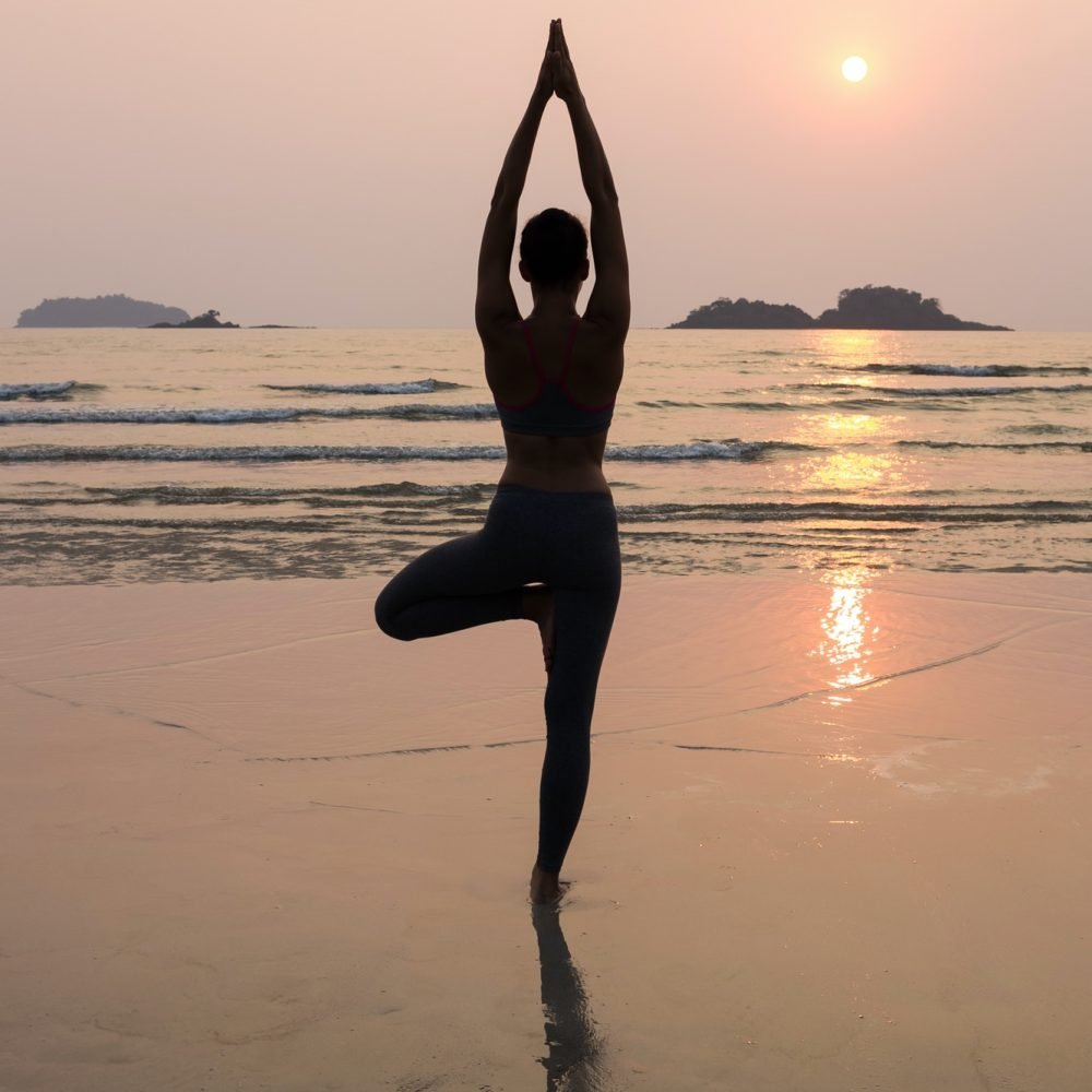 Young slim woman practicing pose from yoga on the beach at sunset